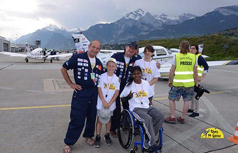 enfants ordinaires et extra ordinaires posent devant un avion avant leur baptême de l'air